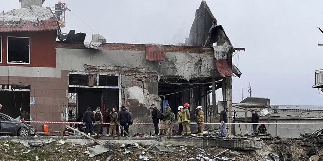 Hulpverleners ruimen maandag het puin op na een luchtaanval op een bandenwinkel in de westelijke stad Lviv, Oekraïne.