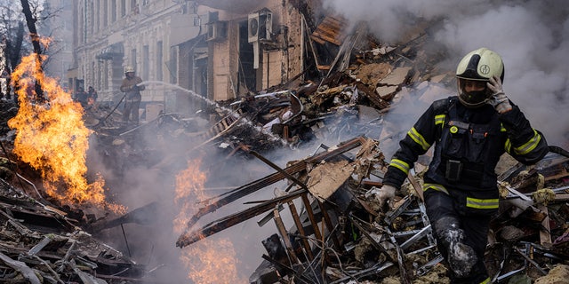 Hulpverleners worden ter plaatse gezien nadat een gebouw werd verwoest bij een Russische raketaanval in het centrum van Kharkiv