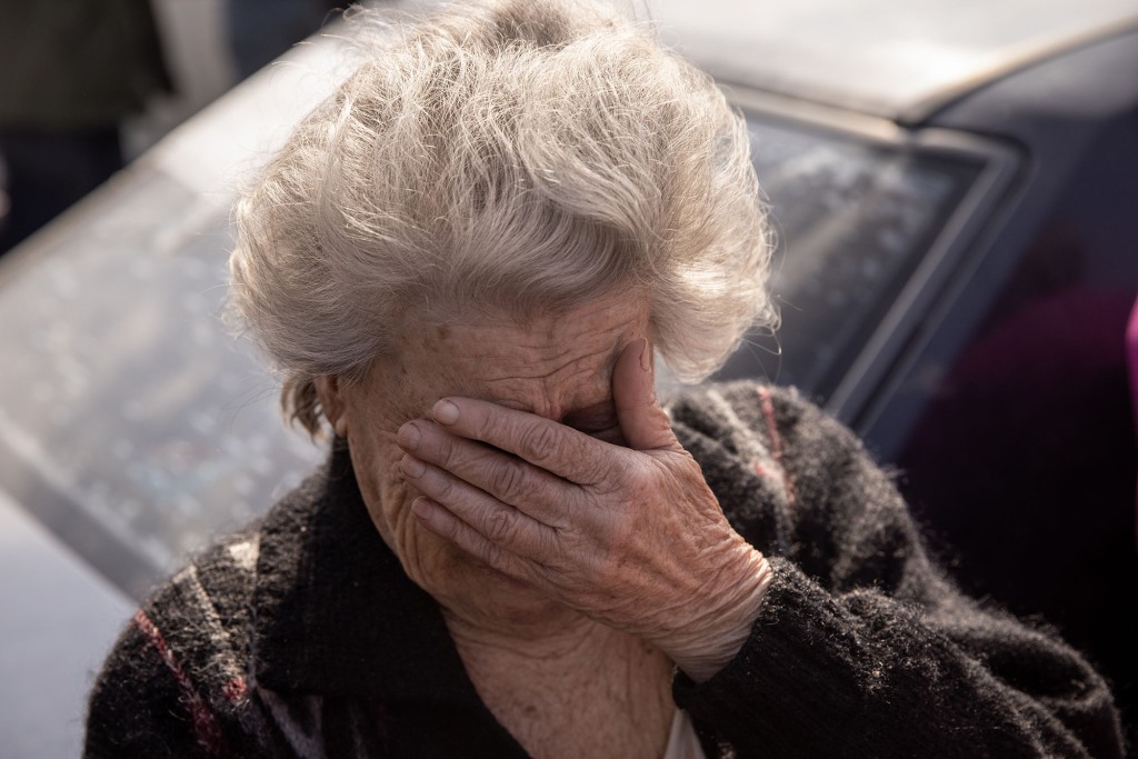 Dina, 81 uit Mariupol, reageert na aankomst met de auto op een evacuatiepunt voor mensen die Mariupol, Melitopol en omliggende door Rusland gecontroleerde steden ontvluchten op 2 mei 2022 in Zaporizja, Oekraïne. 