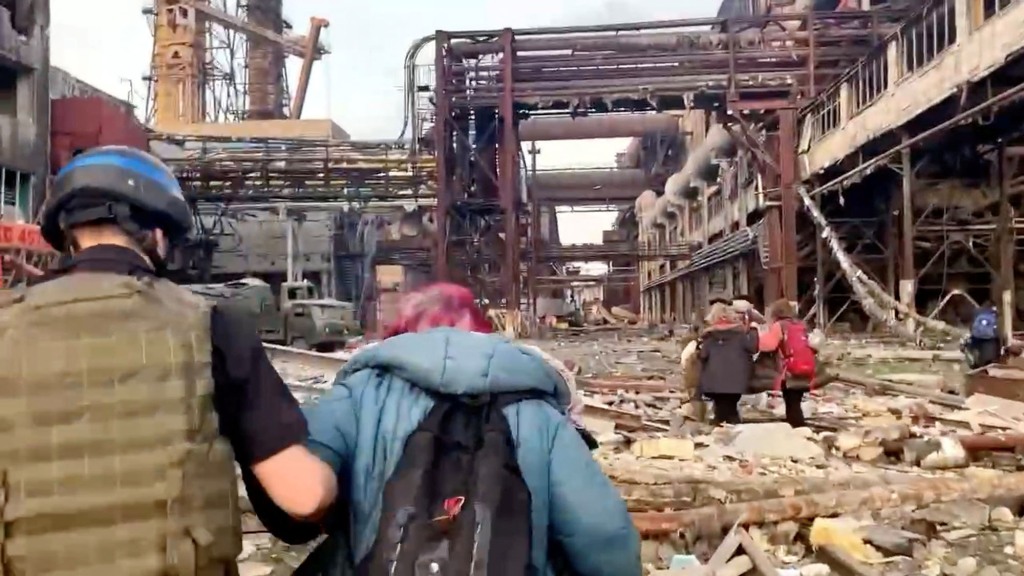 Leden van het Azov-regiment lopen met burgers mee tijdens de door de VN geleide evacuaties van de uitgestrekte staalfabriek Azovstal, bijna twee maanden in een belegeringsoorlog tegen de stad door Rusland tijdens de invasie, in Mariupol, Oekraïne op deze foto van een bericht uitgebracht op 1 mei 2022. 