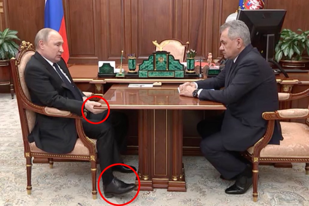 Vladimir Poetin wordt gezwollen gezien terwijl hij een tafel vasthoudt terwijl hij in zijn stoel ligt tijdens een televisieontmoeting met zijn minister van Defensie te midden van geruchten dat de Russische sterke man tegen kanker vecht.