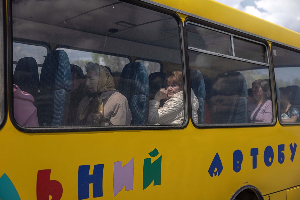 Intern ontheemden zitten in een bus na aankomst uit de frontliniestad Urekiev, op het evacuatiepunt in Zaporizja, Oekraïne, 02 mei 2022