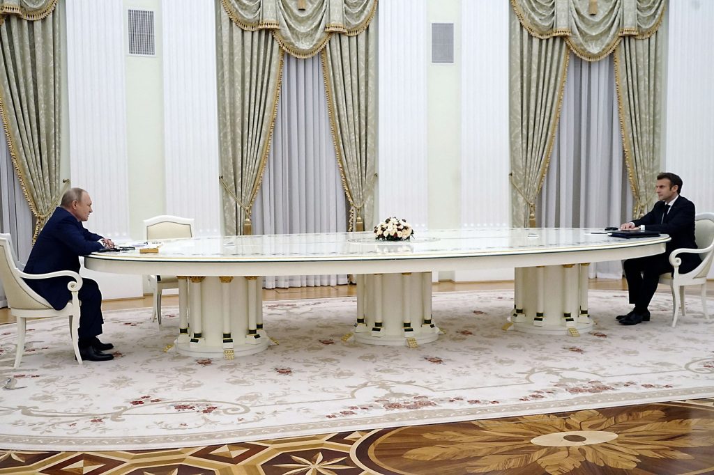 Poetin en Marcon zitten tegenover elkaar aan een tafel in Moskou