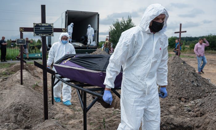 Arbeiders dragen een kist met het lichaam van een niet-geïdentificeerde persoon die is omgekomen tijdens de Russische bezetting van Bucha op 11 augustus.