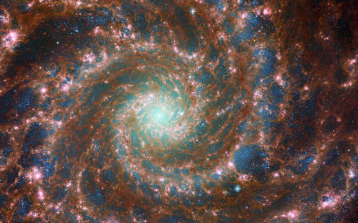 M74 straalt op zijn best in deze optische/mid-infrarood composietafbeelding, die gegevens bevat van de NASA/ESA Hubble-ruimtetelescoop en de NASA/ESA/CSA James Webb-ruimtetelescoop.  & nbsp;  / tegoed: Europees Ruimteagentschap