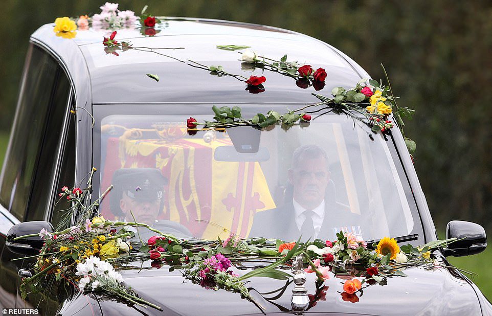 Leden van het publiek gooiden bloemen en boeketten bloemen die het koninklijke paradijs bedekten bij de aankomst van de koningin in Windsor op maandagmiddag.