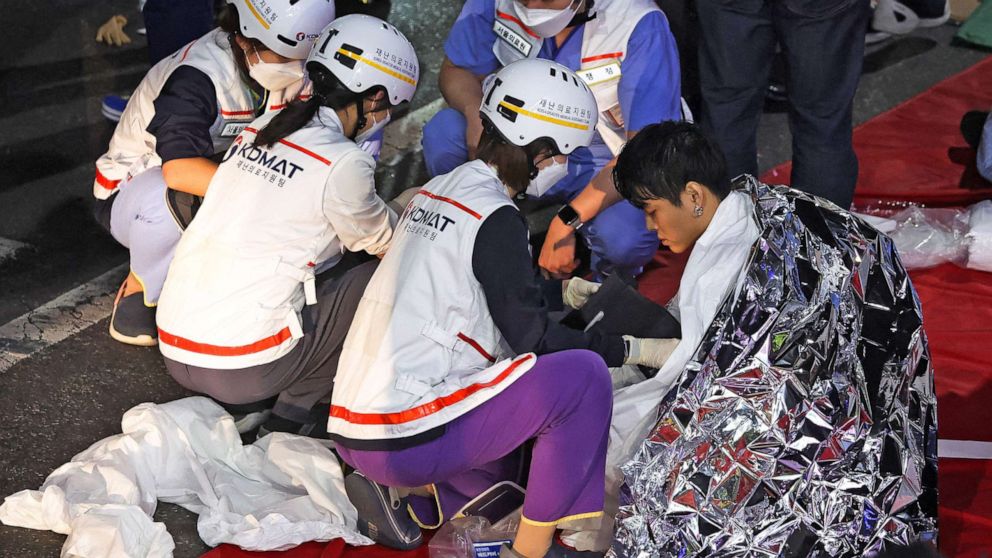 Foto: Een man krijgt medische hulp van reddingsteamleden op de plaats waar tientallen mensen gewond raakten tijdens een stormloop tijdens het Halloween-festival in Seoel, Zuid-Korea, 30 oktober 2022. 