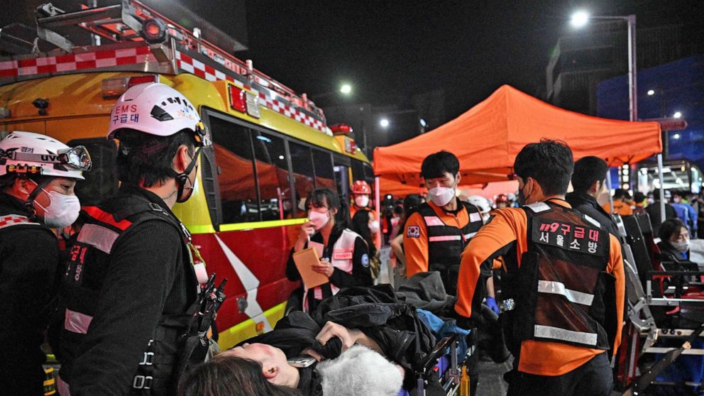 Foto: Medisch personeel zorgt voor een persoon op een brancard nadat tientallen gewond waren geraakt bij een stormloop, nadat mensen op 30 oktober 2022 de smalle straatjes in de wijk Itaewon in de stad hadden bevolken om Halloween te vieren in Seoel, Zuid-Korea.