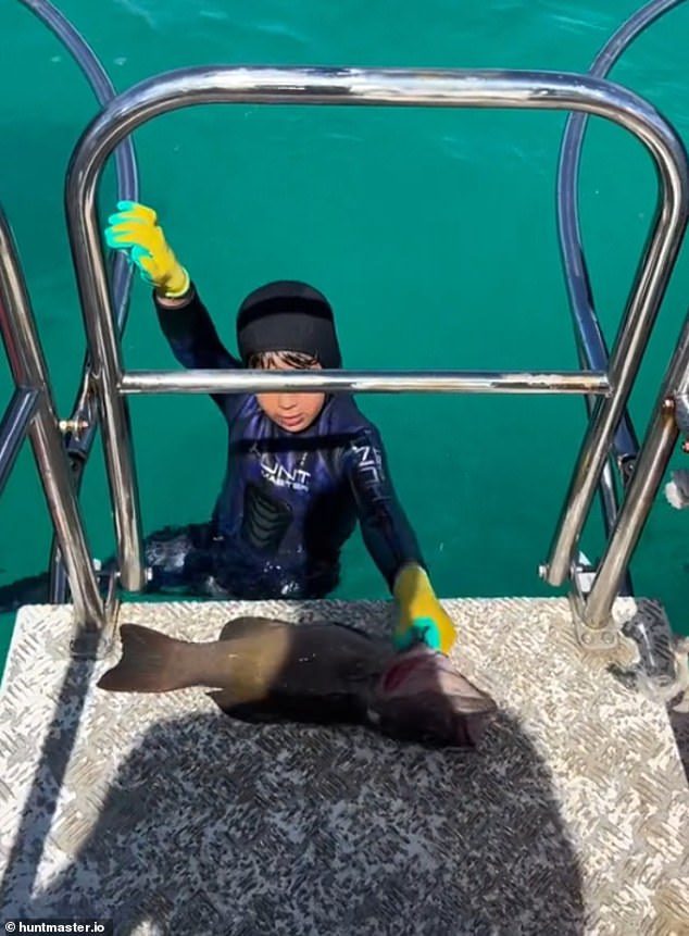 De jonge speervisser Manny kweekt zijn vis op het duikplatform achter de boot