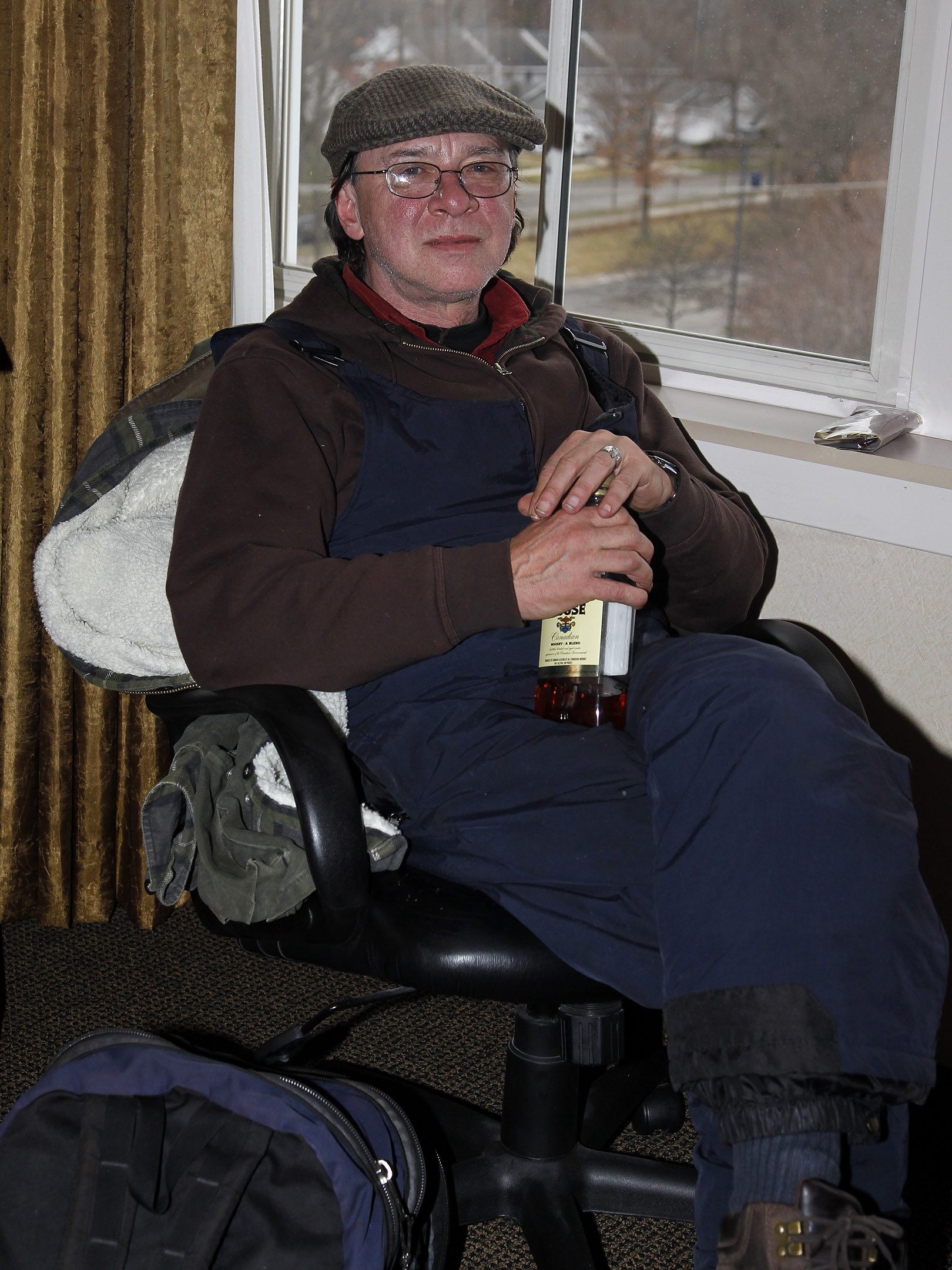 Anthony Ciccone zit op een stoel met een fles whisky in zijn hand.
