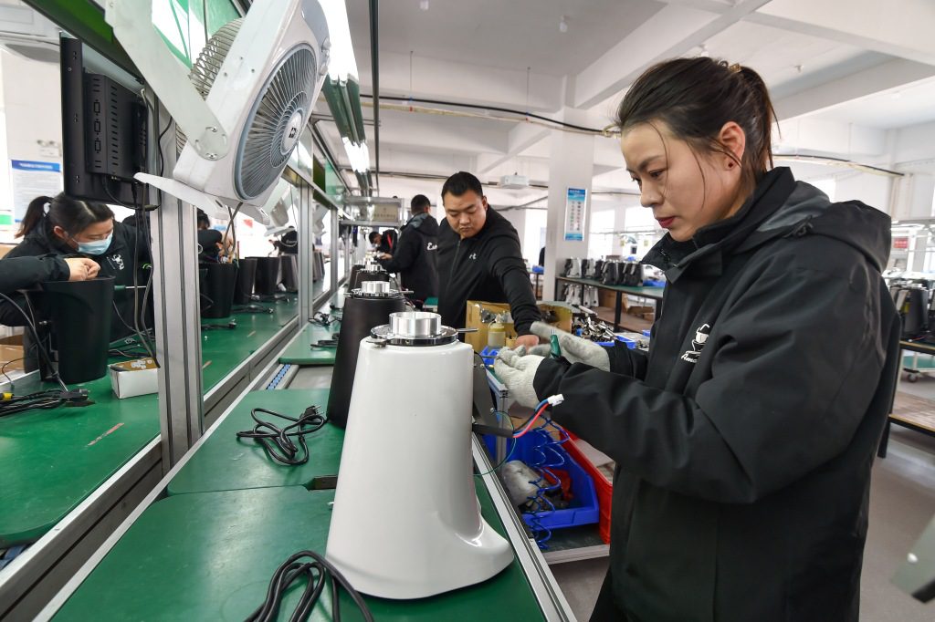 Een arbeider assembleert een bonenmolen voor export naar Europa, Japan en Zuid-Korea in een fabriek in Suqian, de Oost-Chinese provincie Jiangsu, 28 februari 2023.