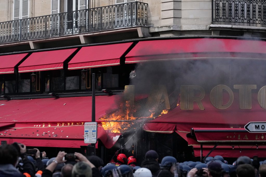 De paraplu van restaurant La Rotonde brandt af tijdens een demonstratie donderdag 6 april 2023 in Parijs. 