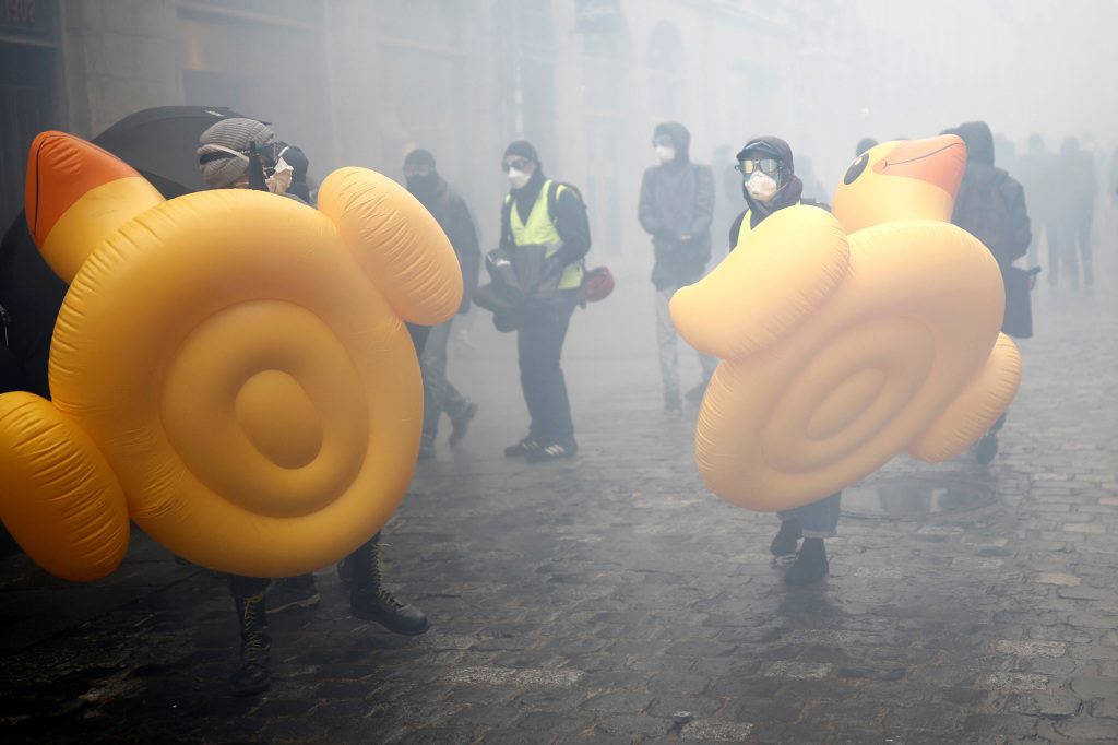 Gemaskerde demonstranten dragen opblaasbare eenden in Rennes