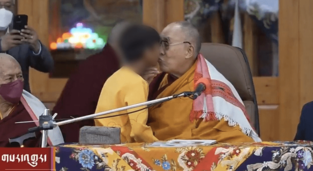 De Dalai Lama gaat verder met het kussen van de jongen op de lippen, zoals afgebeeld.