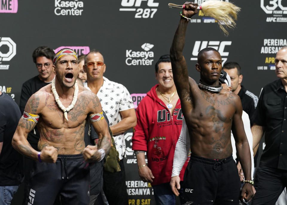 UFC 287 middengewicht kampioen Alex Pereira, links, en Israel Adesanya staan ​​tegenover het publiek na een ceremoniële weging op vrijdag 7 april 2023 in Miami.  Pereira verdedigt zaterdag zijn titel tegen Adesanya.  (AP Foto/Marta Lavandier)