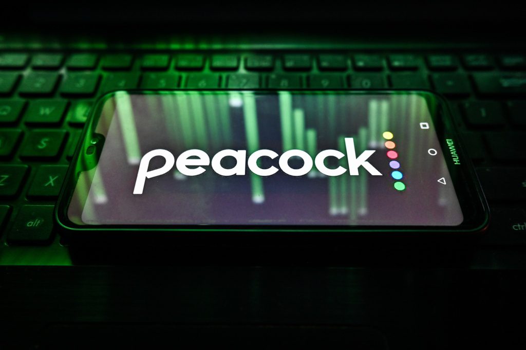 Peacock-logo op de telefoon zittend op het toetsenbord