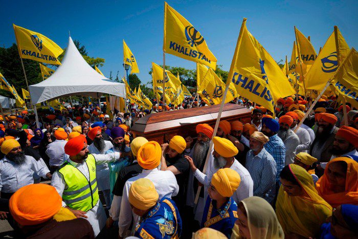 Rouwenden dragen de kist van Sikh-leider Hardeep Singh Nigar tijdens een begrafenisstoet in Surrey, Canada, in juni. 