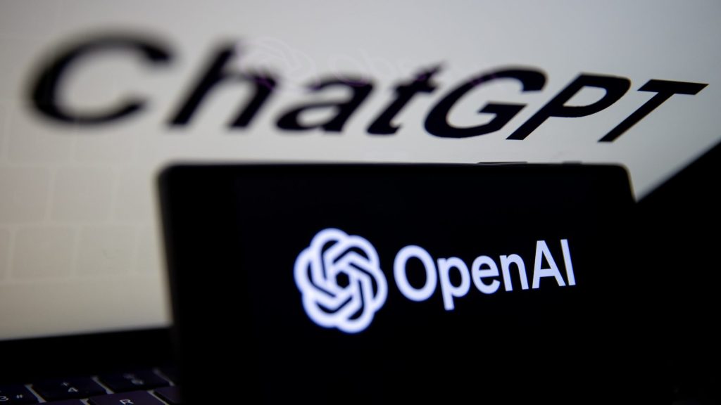 Het OpenAI-logo wordt samen met het ChatGPT-logo weergegeven op het scherm van de mobiele telefoon voor het computerscherm