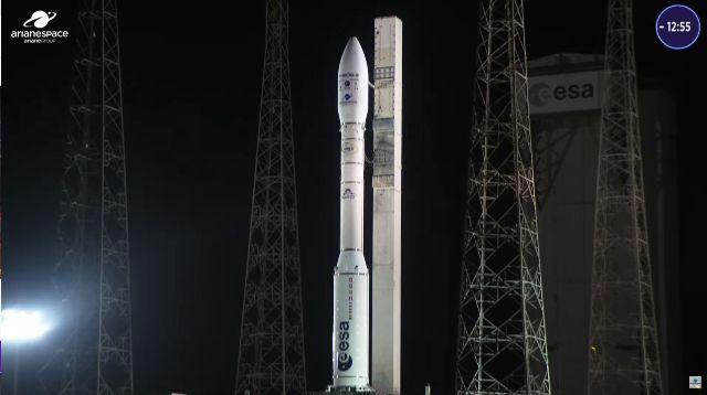 A white Vega rocket stands on its launch pad with lightning towers around it