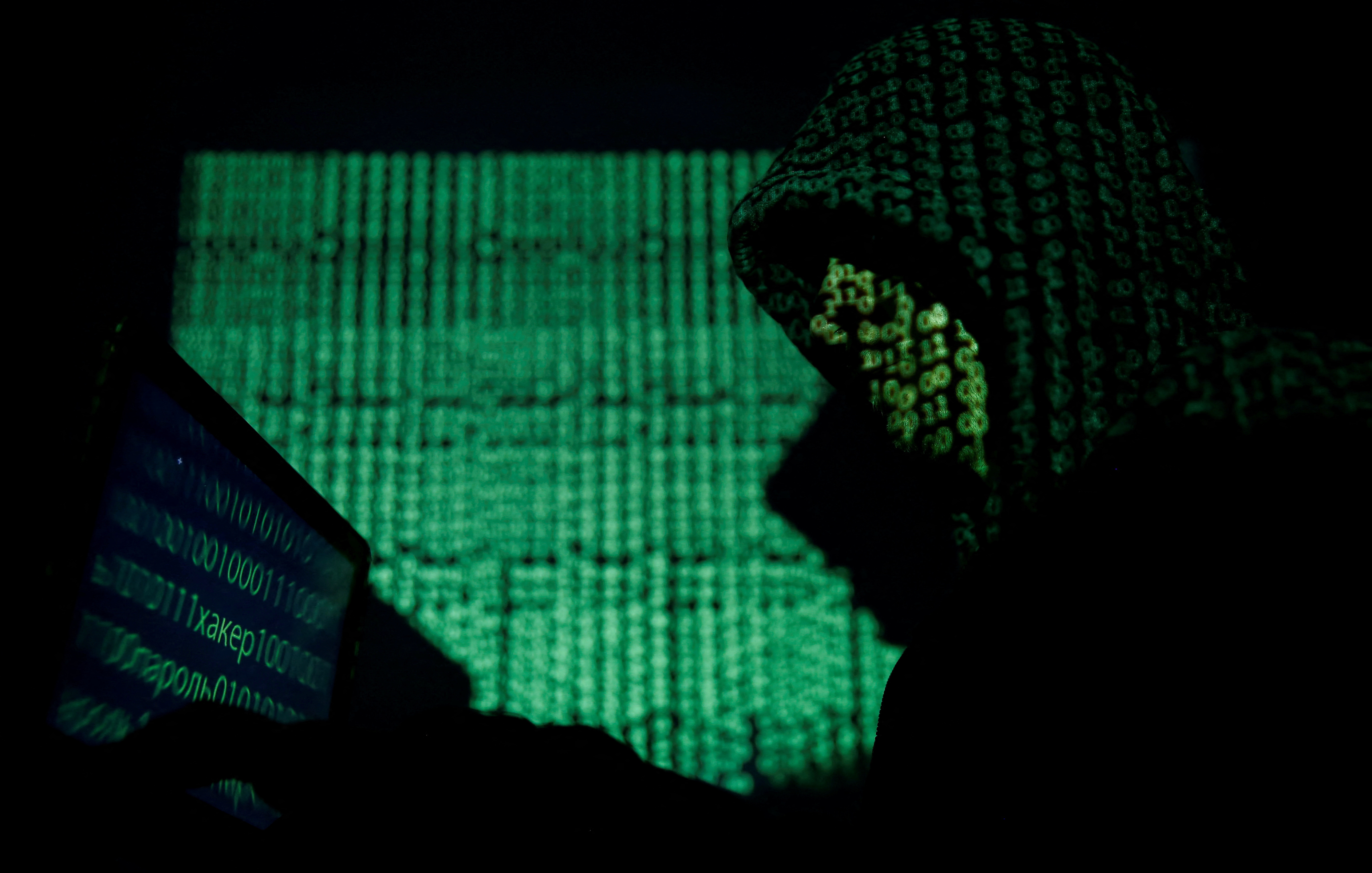 Een gemaskerde man houdt een laptop vast terwijl hij de elektronische code in deze illustratie te zien krijgt