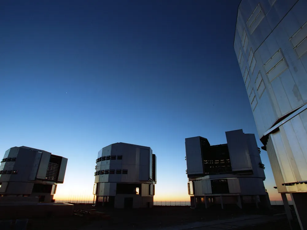 Vier grote telescopen onder de avondhemel