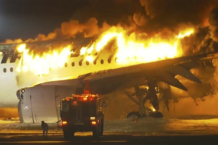 In deze afbeelding uit een video vat een vliegtuig van Japan Airlines vuur op de landingsbaan van Haneda Airport op dinsdag 2 januari 2024 in Tokio, Japan.  (NTV via AP)
