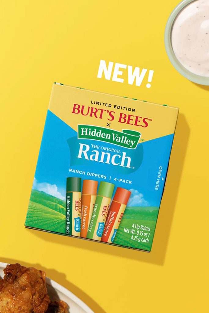 Een verzameling Burt's Bees x Hidden Valley Ranch lippenbalsems met vleugels en een ranch op de achtergrond.