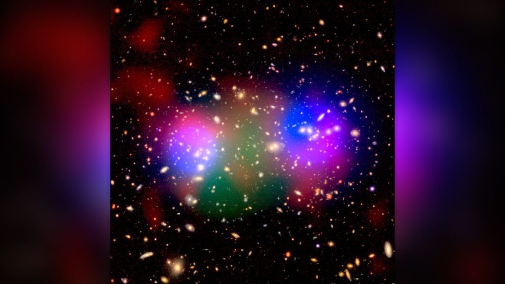 A galaxy cluster colorized to show invisible dark matter (blue) alongside regular, visible matter (red, green, and orange).