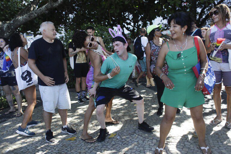 Madonna-fans dansen op vrijdag 3 mei 2024 buiten het Copacabana Palace Hotel waar Madonna verblijft voor haar concert in Rio de Janeiro, Brazilië. Madonna sluit haar tour zaterdag af met een gratis concert op Copacabana Beach.  (AP-foto/Bruna Prado